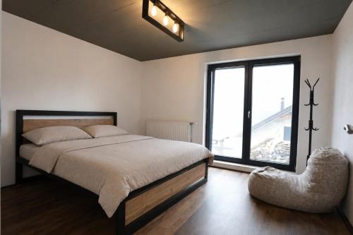 a bedroom with a bed and a large window at Black Villa in Prizren
