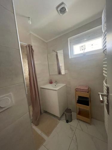 a white bathroom with a sink and a window at T2 avec terrasse privative Berre-l'Étang in Berre-lʼÉtang