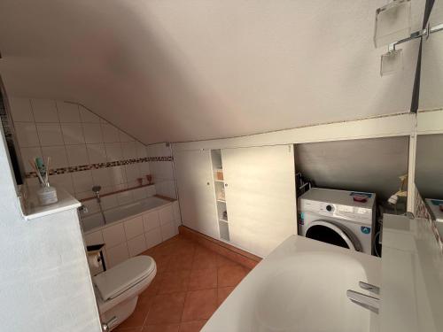 a small bathroom with a toilet and a washing machine at Niederrhein Suite Kerken in Kerken