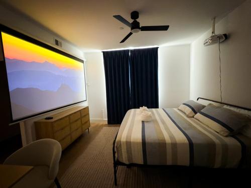 a bedroom with a large flat screen tv and a bed at 1 Block to Beach 150" Theater PS5 Arcade in Seaside Heights