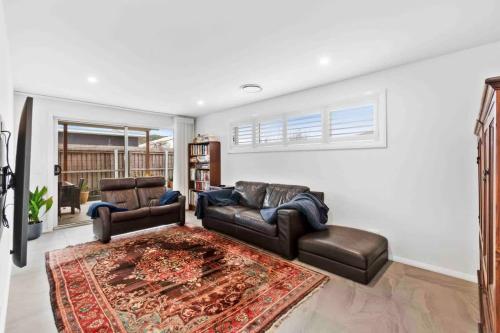 a living room with two couches and a rug at Tomakin Tonic in Tomakin