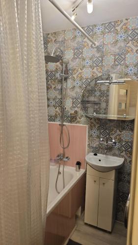 a bathroom with a shower and a sink and a tub at Apartament Tkaczy in Kowary