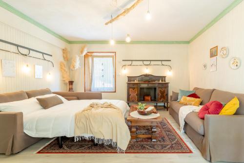 a living room with a large bed and a couch at Dimora Pellegrino in Torre Pellice