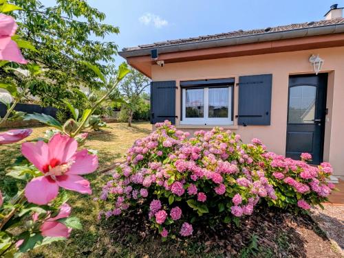 a house with pink flowers in front of it at VILLA climatisée - 4 étoiles - 75 m2 avec Jardin pour 3 personnes - à 10 min de Besançon in Dannemarie-sur-Crête