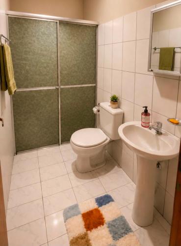 a bathroom with a toilet and a sink and a shower at Casa no Centro Vilhena in Vilhena