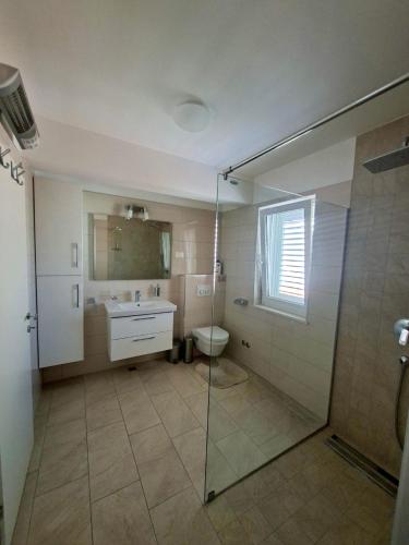 a bathroom with a shower and a sink and a toilet at Apartments Marino in Supetar