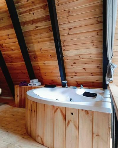 a bath tub in a room with a wooden wall at Kaçkin House ayder in Çamlıhemşin