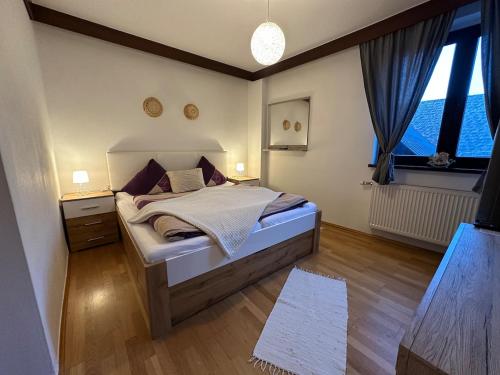 a bedroom with a bed and a large window at Max and Moritz Top 7 in Liebenau