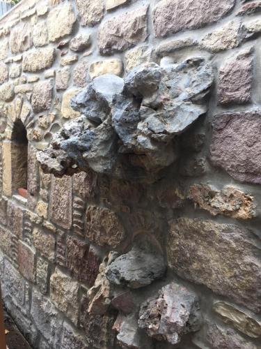 a stone wall with a gargoyle on it at Hotel Pelagos Studios in Platána