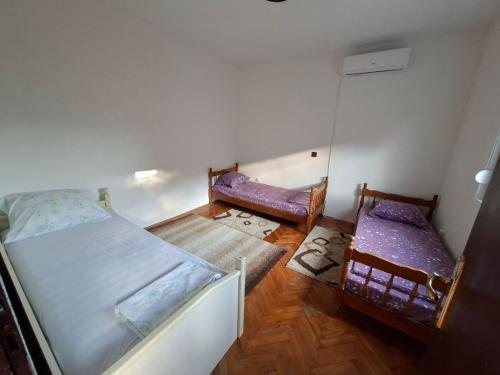 a small bedroom with two beds and a mirror at Mareza in Podgorica