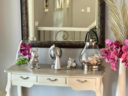 a dressing table with a mirror and flowers on it at Art-Villa SeLena in Bar