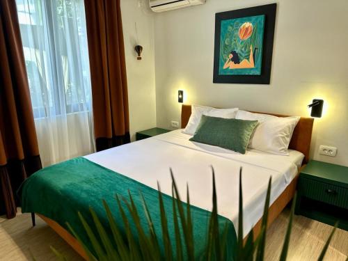 a bedroom with a bed with white sheets and green accents at Art-Villa SeLena in Bar