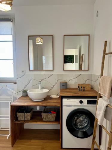 a bathroom with a washing machine and a sink at La pause Saumuroise in Saumur