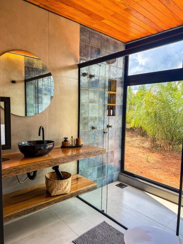 a bathroom with a sink and a glass shower at Cabana Komodo Bonito in Bonito