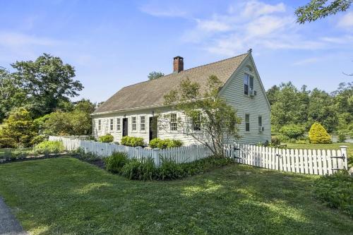 an old white house with a white fence at Bluestone Cottage in Goshen