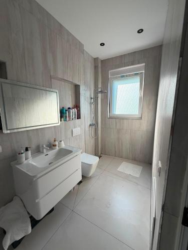 a white bathroom with a sink and a toilet at Villa Hasani in Hamallë