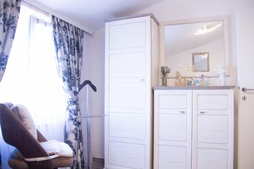 a bedroom with white cabinets and a mirror at Sunny oasis in Marčelji