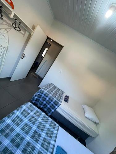 a bedroom with a bed with a checkered blanket at Casa tranquila próximo ao centro e a Unigran in Dourados