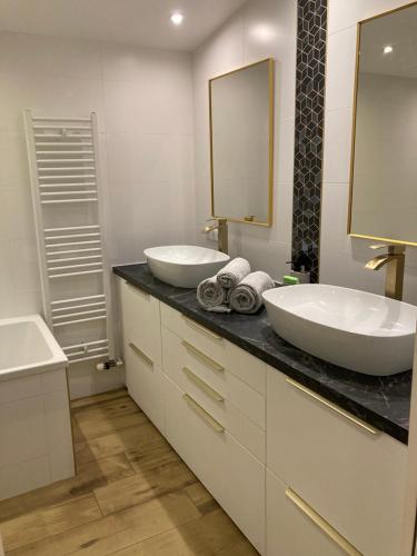 a bathroom with two sinks and a large mirror at Le Tilleul in Pluvigner