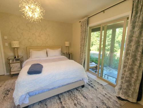 a bedroom with a bed and a large window at Davidson Lake House in Sooke