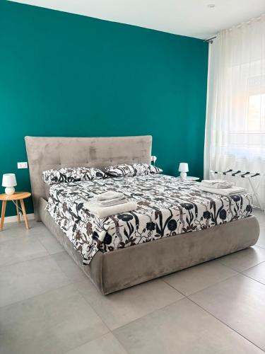a bed in a room with a blue wall at Corte del Gallo in Legnano