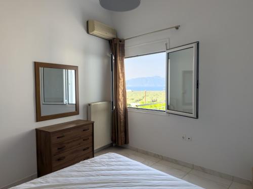 a bedroom with a bed and a window and a dresser at Modern Sea View Apartment - Arkitsa Rentals in Arkitsa