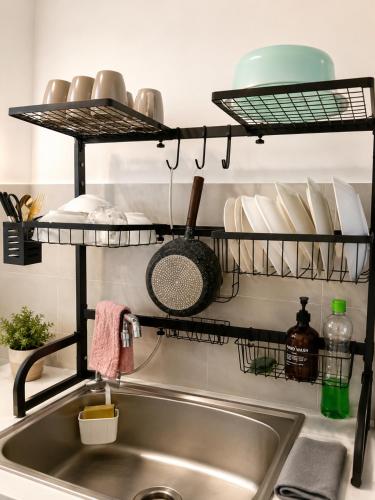 a kitchen sink with a shelf above it with dishes at Atlantis Residences by UVM Stay -4 Pax in Malacca