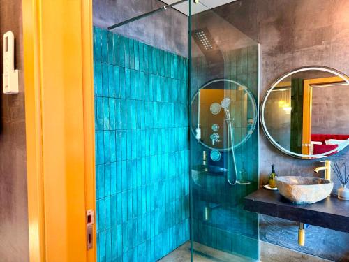 a bathroom with a shower with a sink and a mirror at Al Dazk in Ribeira Brava