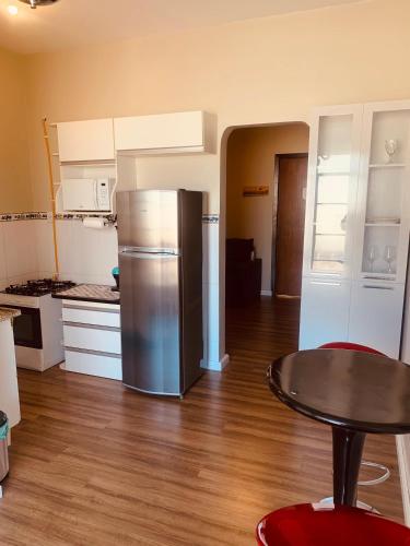 a kitchen with a stainless steel refrigerator and a table at Edifício Marília in Marília