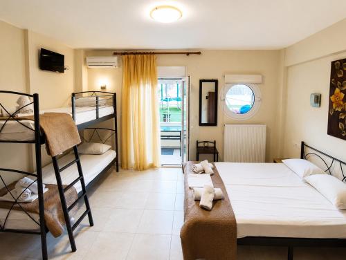 a bedroom with two bunk beds and a window at JONNY'S Rooms in Paralia Katerinis