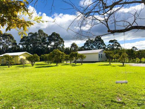 a yard with a house and a swing at Relax a Lodge in Kerikeri