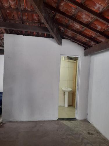 a room with a white wall and a toilet at Casa Vilarejo in Arembepe