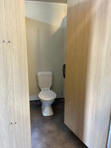 a bathroom with a toilet in a small room at Welcome Bay Hot Pools in Tauranga