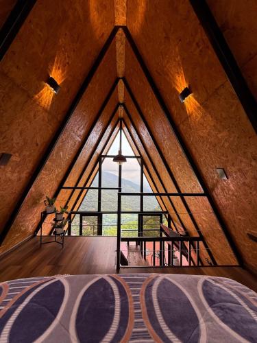 an attic room with a large window in a building at Cabaña Nivura in Palmira