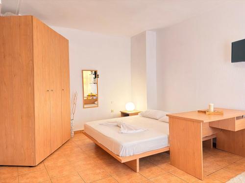 a bedroom with a bed and a wooden cabinet at Studio 28 in Chios