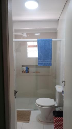 a bathroom with a toilet and a blue towel at Life Pinhalzinho in Pinhalzinho