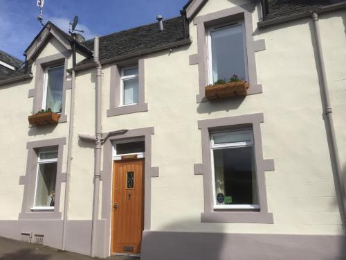 a white house with two windows and a door at Avonlea Self-Catering in Crieff