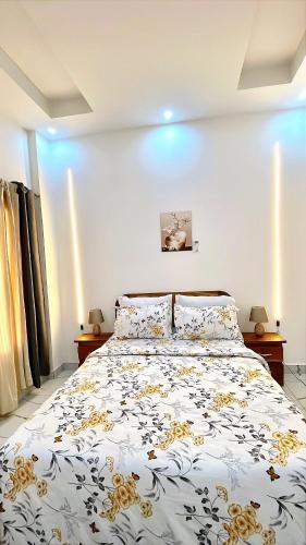 a bedroom with a bed with a yellow and white comforter at Le Cocooning Mermoz-Batrain in Dakar