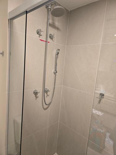 a shower in a bathroom with a glass door at Apê Brisa-5min consulado EUA-garagem in Porto Alegre