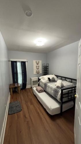 a bedroom with a bed and a wooden floor at Cozy Oneonta Getaway in Oneonta