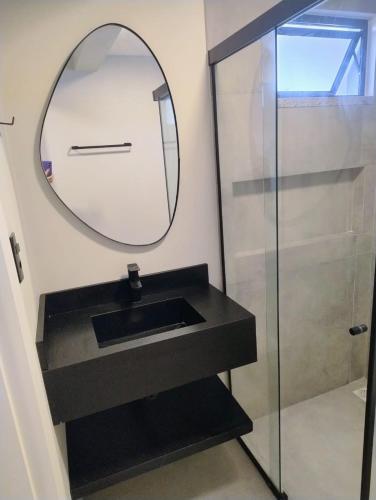a bathroom with a sink and a mirror at Villa Parati Bombinhas Sob Nova Direção in Bombinhas