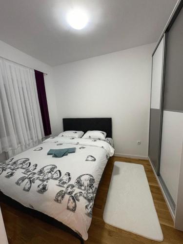 a bedroom with a bed with a black and white comforter at Stan na dan Lana in Vranješ