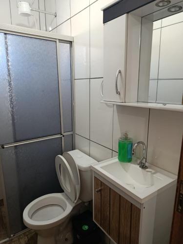 a bathroom with a toilet and a shower and a sink at Pousada Paraiso in Telêmaco Borba