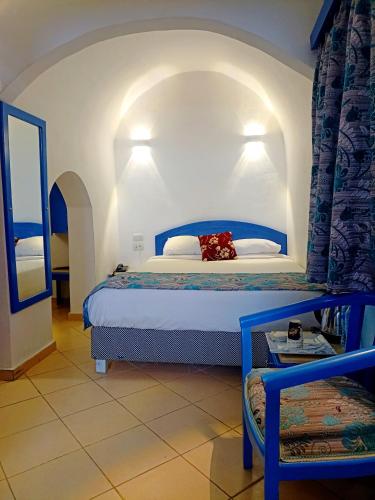 a bedroom with a bed with a blue headboard at kanabesh hotel in Sharm El Sheikh