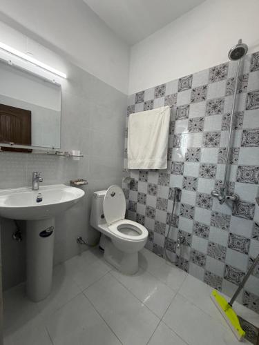 a bathroom with a toilet and a sink at Midways Guest House and Hotels in Islamabad
