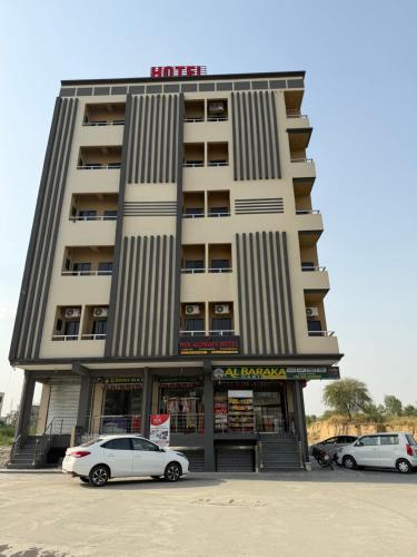 two cars parked in front of a building at Midways Guest House and Hotels in Islamabad