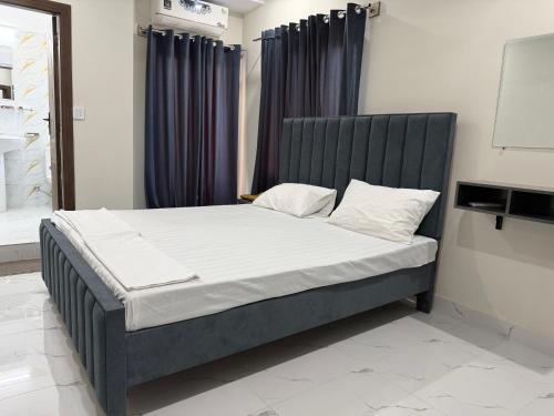 a bed with a black headboard in a room at Midways Guest House and Hotels in Islamabad