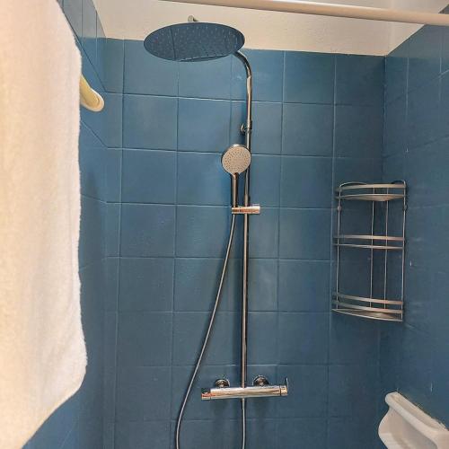 a bathroom with a shower with a blue tiled wall at Captain's View Guesthouse in Kouniádhoi