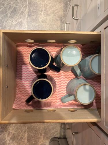 a wooden drawer with a bunch of cups in it at Sea Retreat Nika in Kawazu