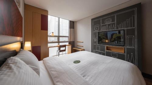 a hotel room with a large white bed and a window at Central Seven Hotel by Kwon Busan Seomyeon in Busan